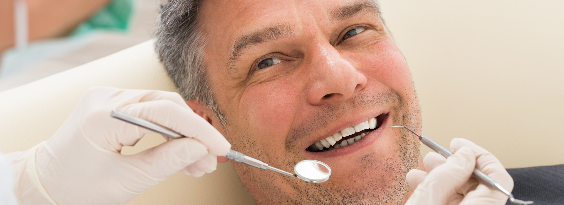 A man receiving dental care with a smile on his face.