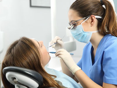 A dental hygienist is performing a teeth cleaning procedure on a patient with a focus on oral care maintenance.